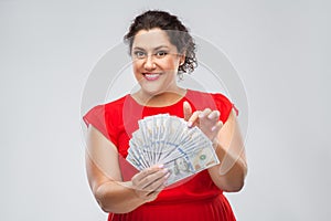 Happy woman holding hundreds of money banknotes