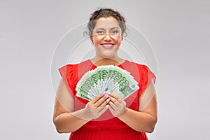 Happy woman holding hundreds of money banknotes