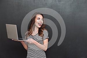 Happy woman holding laptop computer