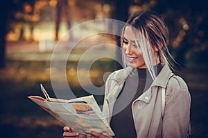 Happy woman holding the map of the city in her hands