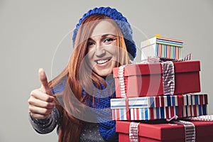 Happy woman holding piled Christmas gifts
