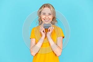 Happy woman holding plastic credit card in her hands