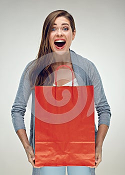 Happy woman holding red paper shopping bag.