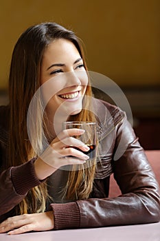 Happy woman holding a refreshment in a restaurant photo