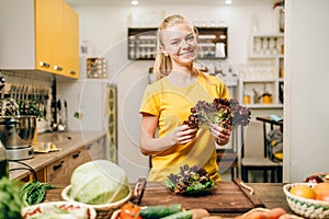 Happy woman holding salad, cooking healthy food