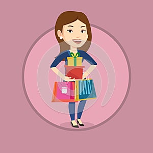 Happy woman holding shopping bags and gift boxes.