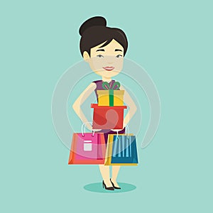 Happy woman holding shopping bags and gift boxes.