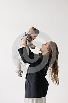 A happy woman is holding a smiling baby girl in black and white outerwear