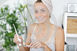 Happy woman holding tooth brush with tooth paste