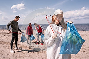 happy woman holding trash bag and