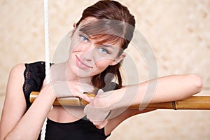 Happy woman holds on bamboo rope ladder