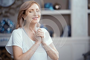 Happy woman holds hands put in prayer pose. Meditation