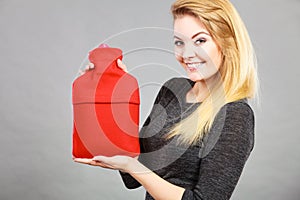 Happy woman holds hot water bottle