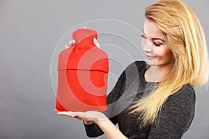 Happy woman holds hot water bottle