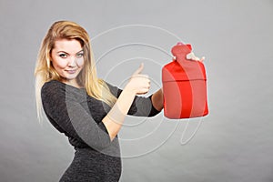 Happy woman holds hot water bottle