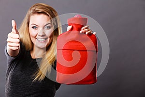 Happy woman holds hot water bottle