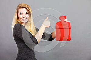 Happy woman holds hot water bottle