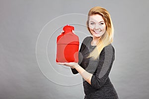 Happy woman holds hot water bottle