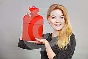 Happy woman holds hot water bottle