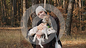 Happy woman holds and petting a dog in the forest