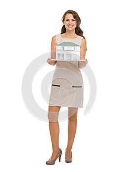 Happy woman homeowner showing scale model of house