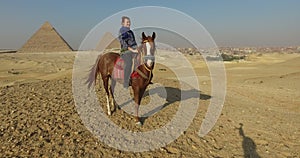 Happy woman on horseback at Giza pyramids complex
