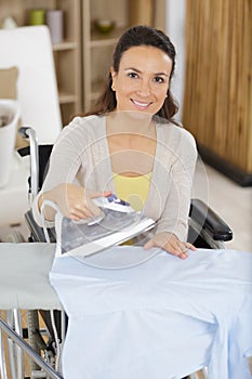 happy woman or housewife ironing at home