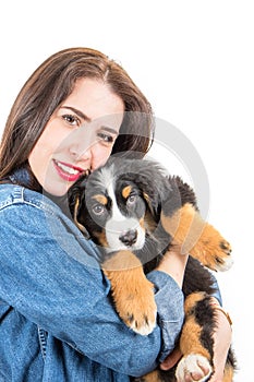 Happy woman huge a puppy of bernese mountain dog