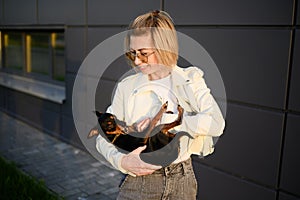 Happy woman hugging foster pet Smooth-haired Russian toy terrier. Love and affection between owner and pet.