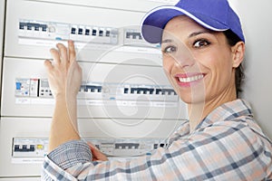 happy woman inspecting fuse board