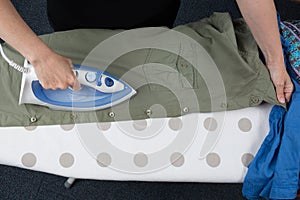 Happy woman Ironing man's shirt with electric Iron