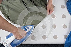 Happy woman Ironing man's shirt with electric Iron