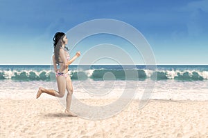 Happy woman jogging on the beach