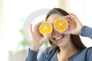 Woman joking with two half orange slices photo