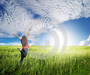 Happy woman jump in grass fields and blue sky