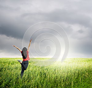 Happy woman jump in grass fields and raincloud