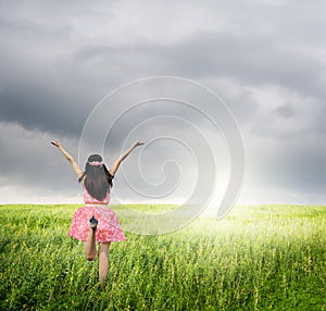 Happy woman jump and raincloud in green field