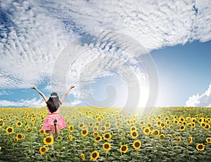 Happy woman jump in sunflower fields and blue sky