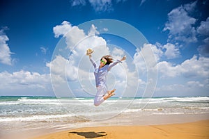 Happy woman jumping at the beach