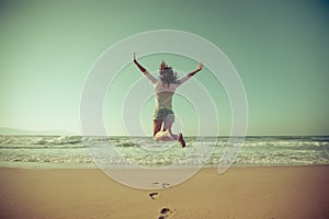 Happy woman jumping at the beach