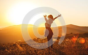 Happy woman jumping and enjoying life at sunset in mountains