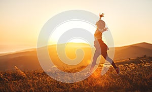 Happy woman jumping and enjoying life at sunset in mountains