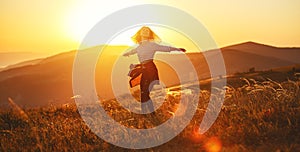 Happy woman jumping and enjoying life  at sunset in mountains