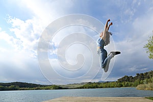 Happy woman jumping in a lake