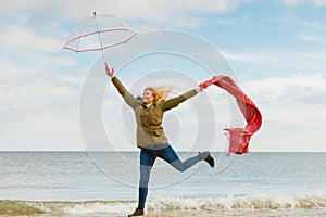 Happy woman jumping with scarf on beach