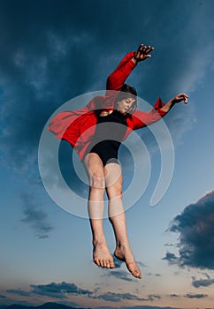 Happy woman jumping up flying levitation in the sky