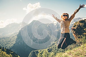 Happy Woman jumping up raised hands mountains