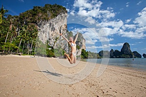 Happy woman jumps at the seashore