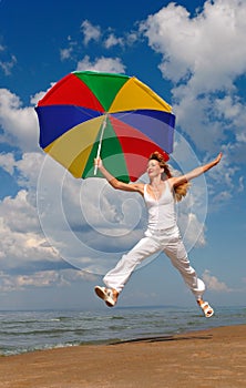 Happy woman jumps with umbrella