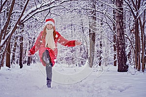 A happy woman kicks the snow, a winter forest with frozen trees